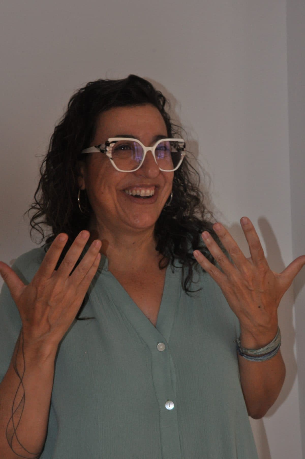 Maria Antònia explicant una idea amb les mans obertes, somrient